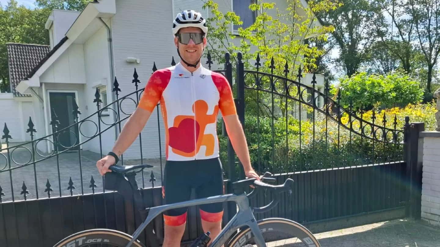 Wesley Kreder draagt het nieuwe wielertenue van Stichting Sport Hard-t, met het oranje logo en het hart op de borst